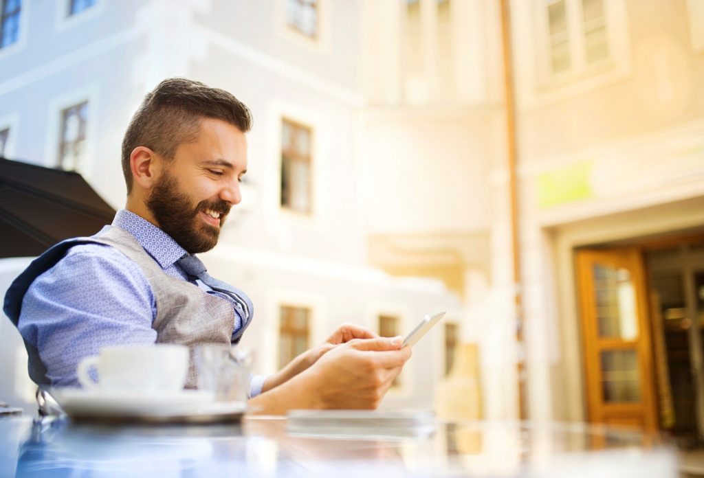 man looking on his smartphone and smiling